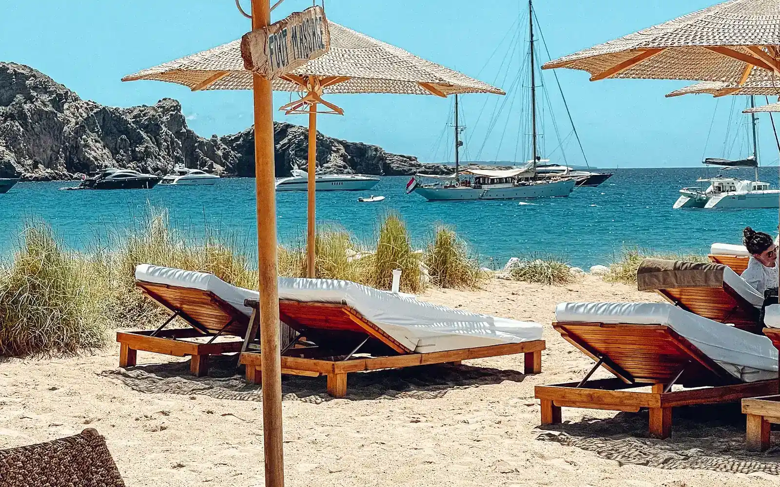 Des transats et des voiliers sur une plage tranquille
