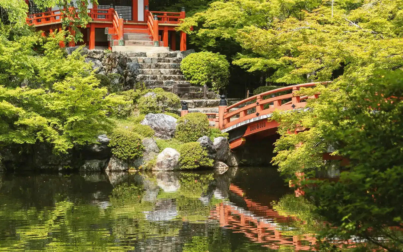 Un pont rouge sur un étang de jardin paisible