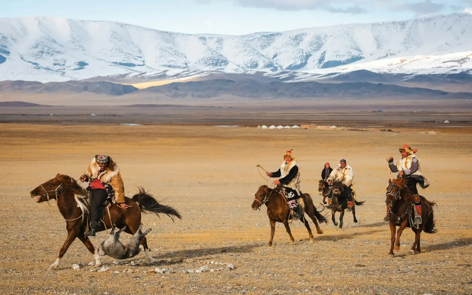 Des cavaliers traversant la steppe sous des sommets enneigés