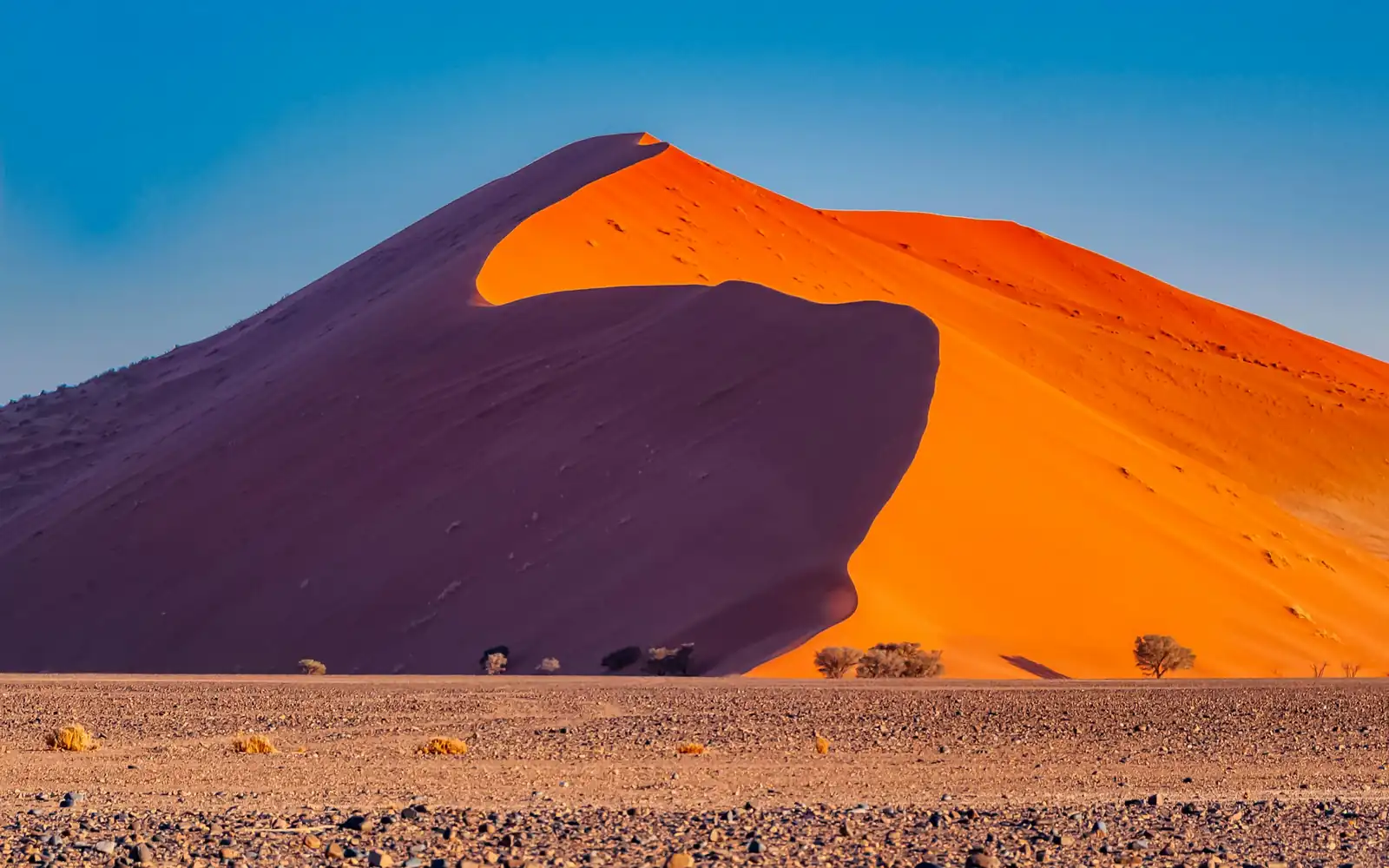 Une dune rouge qui brille au-dessus du désert