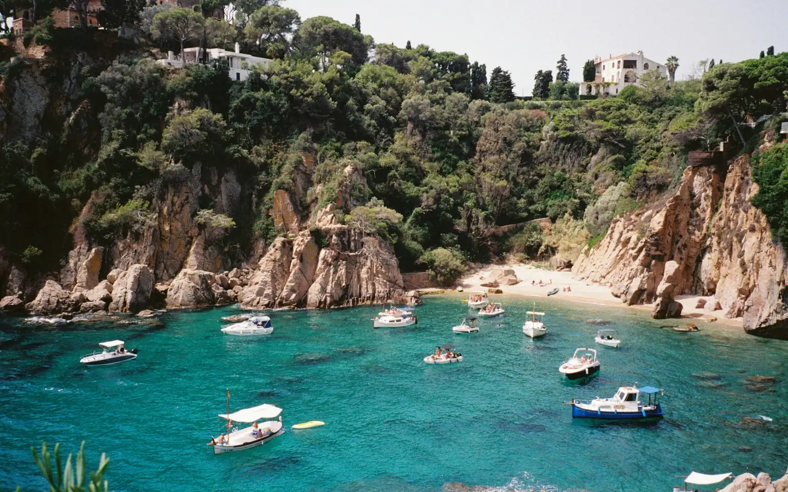 Une crique turquoise avec des bateaux sur la Costa Brava
