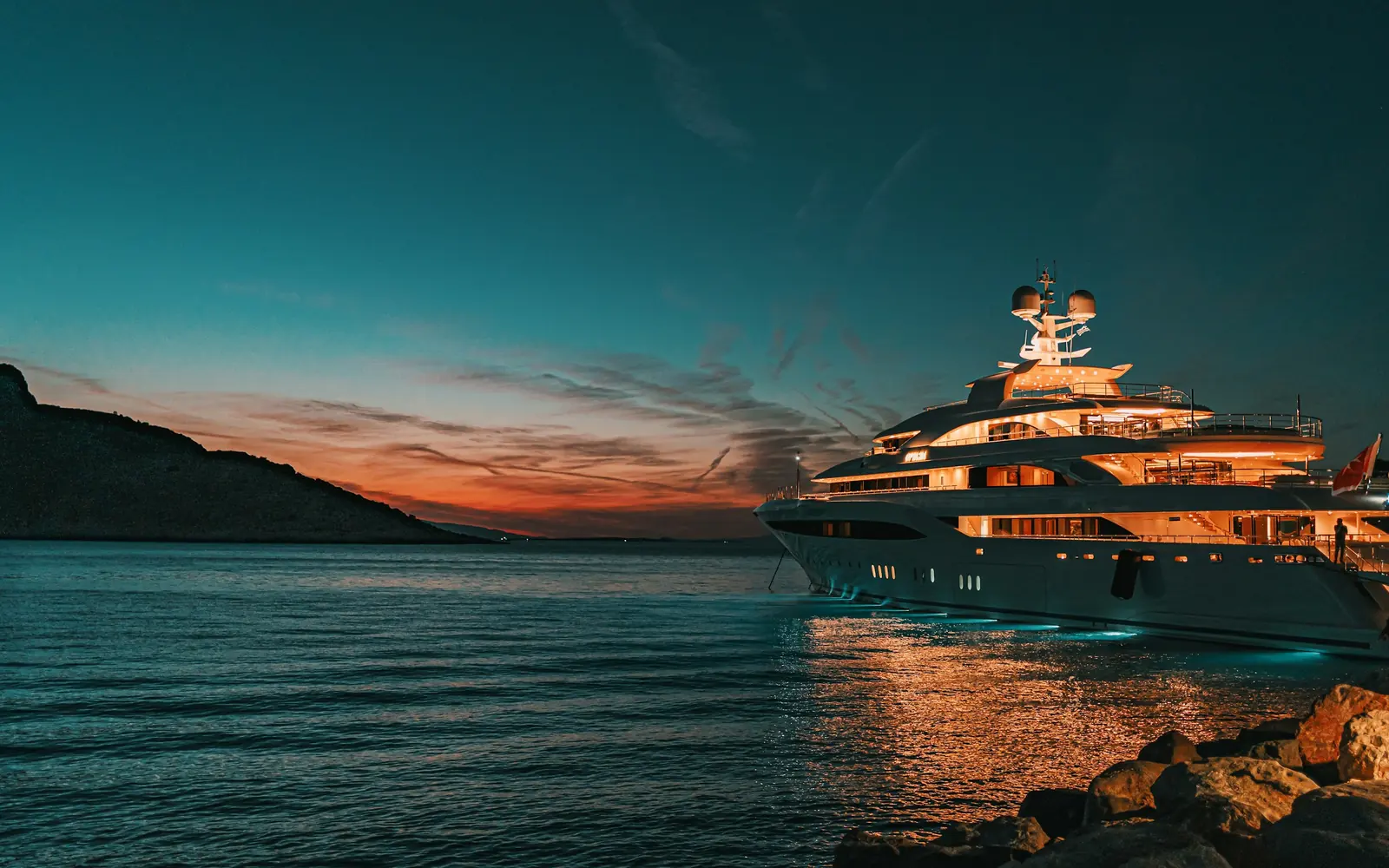 Un superyacht à l’ancre sous un coucher de soleil cuivré
