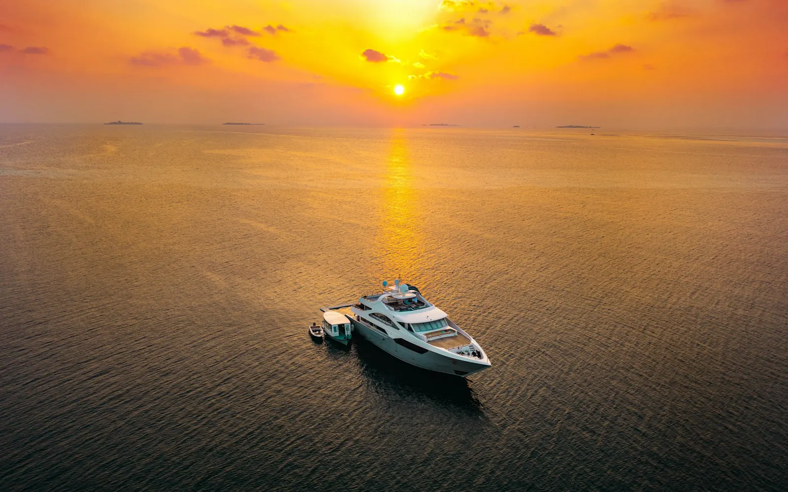 Un yacht seul sur une mer dorée au lever du soleil
