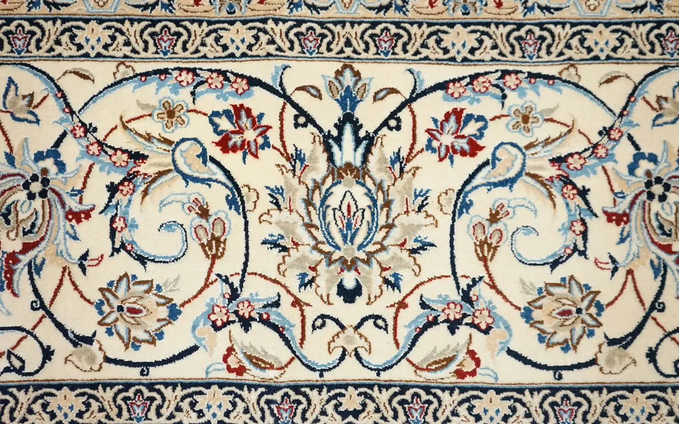 Un tapis de soie ivoire au motif floral fluide