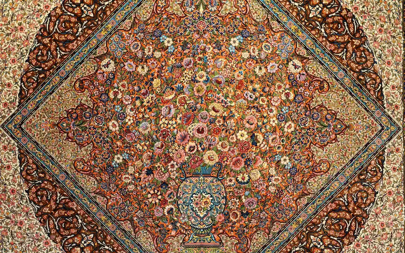 Un tapis de soie avec un médaillon de fleurs s’élevant d’un vase