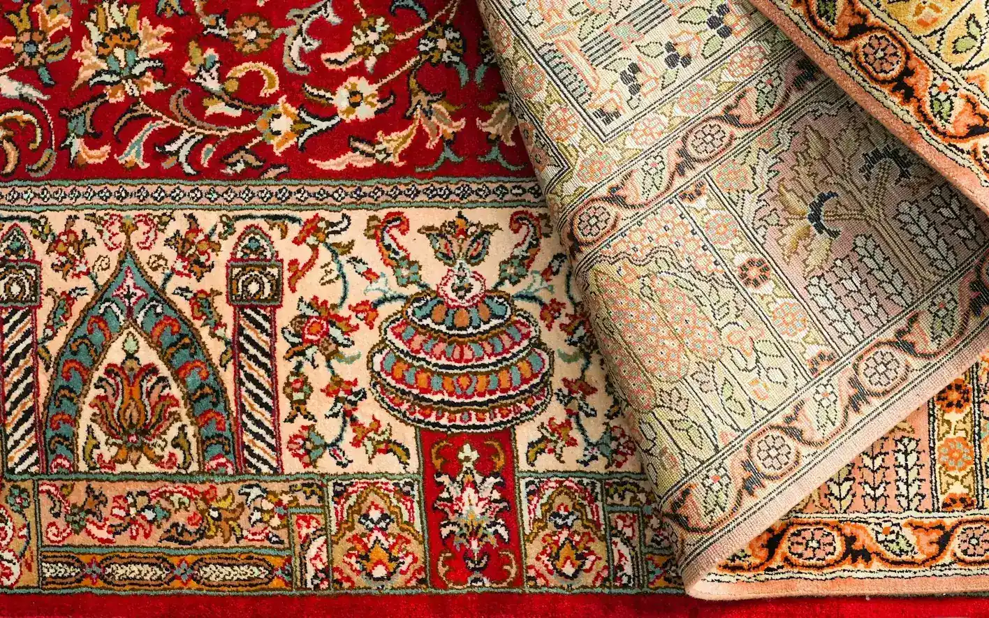 Un tapis persan en soie fait main, un coin retourné pour montrer le tissage