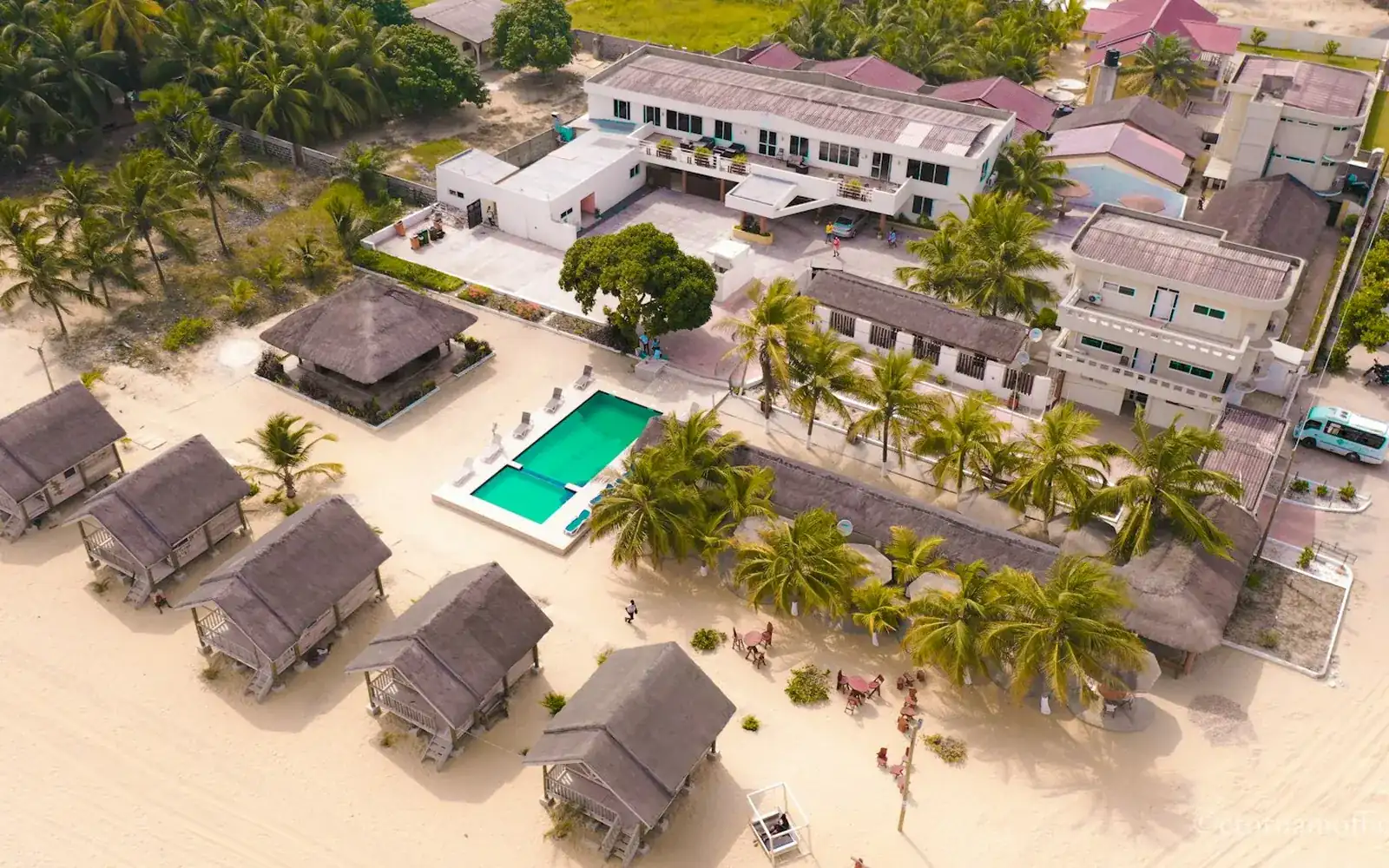 Des villas de plage au bord d’un rivage doré, vues du ciel